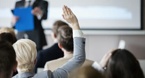 woman raising hand in training session